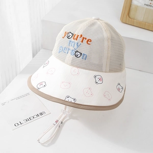 Détail d'un chapeau de soleil respirant pour enfant avec broderie ours et cordon réglable