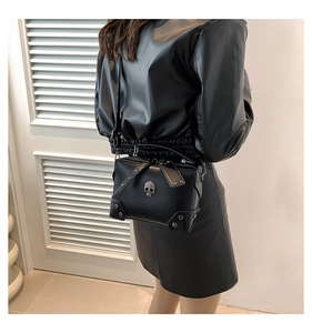 Detail of a black punk PU leather crossbody bag with silver skull and stud embellishments