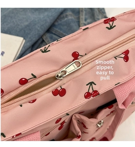 Close-up of smooth metal YKK zipper on a pink tote bag with cherry print patterns