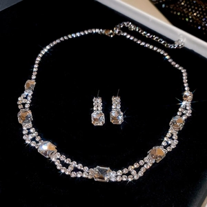 Macro detail of silver necklace and square diamond pendant set on black velvet