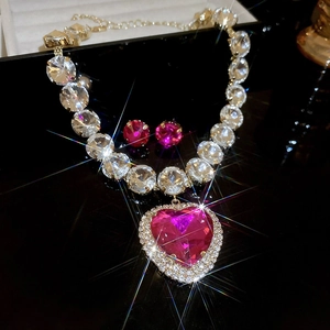 Close-up of geometric pink heart gemstone necklace and stud earrings set in gold finish
