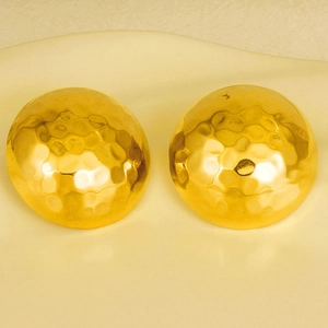 Vue détaillée de boucles d'oreilles dôme dorées avec texture martelée élégante