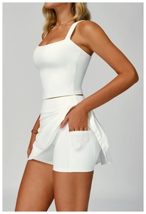 Detail view of white yoga set featuring functional side pockets on tennis skirt shorts