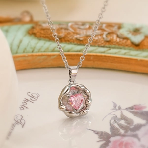 Silver flower necklace with a pink heart gemstone pendant and delicate chain links
