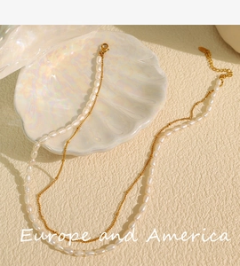 Close-up of double-layered necklace with freshwater pearls and gold chain on shell