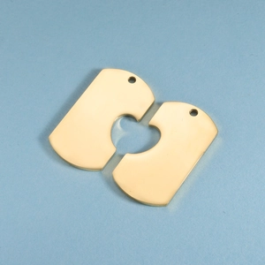 Macro shot of two golden heart-shaped puzzle pendants with polished mirror finish