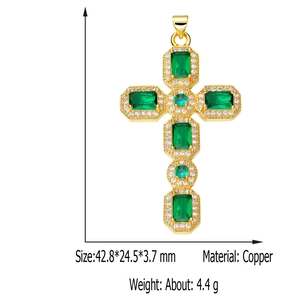Detailed view of a gold-plated copper cross pendant with green emerald-cut gemstones