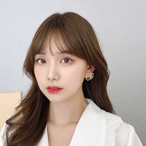 Close-up of heart-shaped pearl earrings with floral oil painting on female model