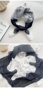 Detail of a black and white square scarf featuring an artistic abstract face line drawing