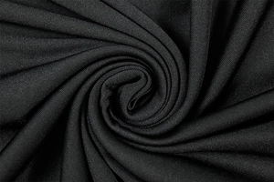 Macro shot of black knit fabric texture with soft ripples and smooth drape for dresses