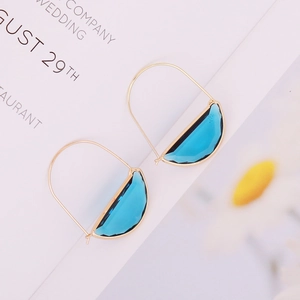 Teal crescent glass earrings with golden metal hooks on a white minimalist background