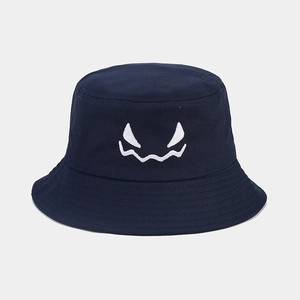 Detailed view of white monster face embroidery on navy cotton canvas bucket hat