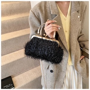 Détail du sac de soirée noir en plumes avec poignée perle et bandoulière dorée