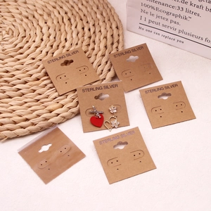 Asymmetric 925 sterling silver heart and flower earrings on kraft paper display cards