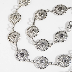 Detailed close-up of vintage silver sunflower metal waist chain with lobster clasp