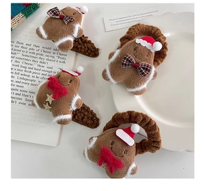 Detail view of plush gingerbread man hair clips and elastics for Christmas styling
