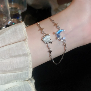 Dettaglio dei bracciali in argento con cuore in opale, luna blu e ciondoli a forma di stella