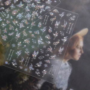 Detail of 3D holographic nail stickers featuring cranes, butterflies and pearl accents