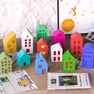 Miniature colorful house figurines set with minimalist geometric windows and heart cutouts