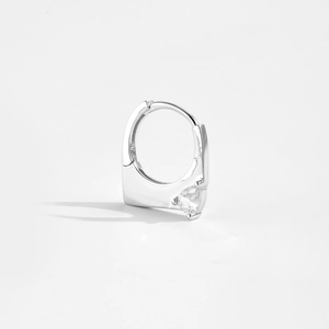 Macro shot of silver S925 hoop earring featuring a heart-shaped zircon on white background