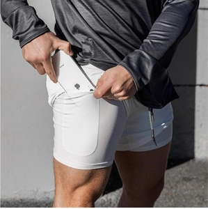 Detail showing high-stretch compression pocket on men's white fitness shorts for phone storage