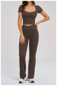 Detail of high-waisted flared yoga pants with cross V-waist and fitted crop top