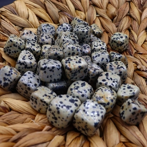Polished cube-shaped dalmatian jasper stones in a woven tray for craft jewelry making