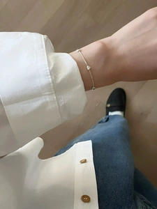 First-person POV showing a dainty S925 sterling silver heart bracelet on a female wrist
