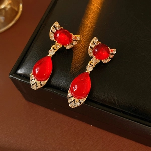 Detail of vintage red teardrop earrings with crystals on a black leather jewelry case