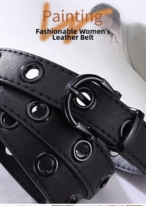 Detail shot of black fashion belt featuring dual rows of metallic eyelets and textures