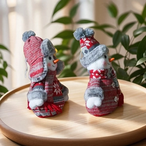 Detail of Christmas snowman plush figurines in red and white knit on wooden tray