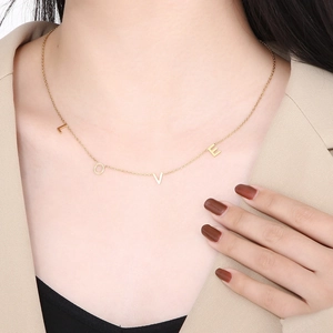 Collier doré avec pendentifs lettres LOVE porté par un mannequin élégant