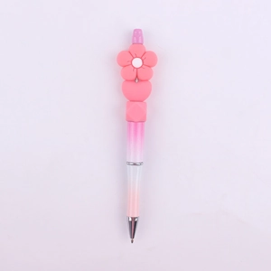 Close-up of pink beaded pen with cute silicone daisy flower, heart and square beads