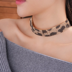 Detail of leopard print rhinestone choker necklace on model featuring gold and black stones
