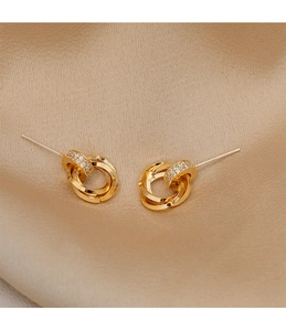 Detail of gold geometric earrings with triple-ring design and pavé crystal accents