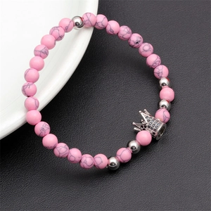 Close-up of pink marble stone beads bracelet with a black zircon silver crown charm