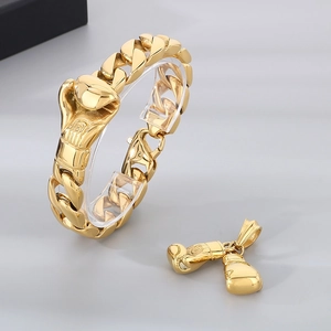 Macro shot of gold stainless steel Cuban chain bracelet with boxing glove pendant design
