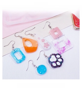 DIY resin earrings in geometric shapes like cat paws and stars made with silicone molds