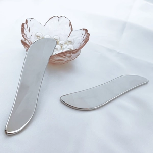 Macro detail of two heart-shaped silver 304 stainless steel Gua Sha facial massage tools