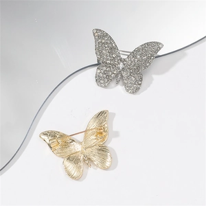 Detailed view of rhinestone butterfly brooch showing silver front and gold metal back pins