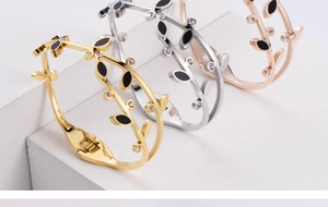 Detailed view of leaf-shaped spring bracelets in gold, silver and rose gold with zircons