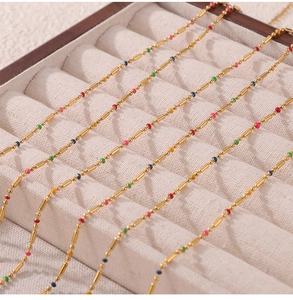 Detailed view of titanium steel necklaces with colorful rice beads in a beige jewelry box