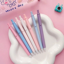Set of six pastel macaron retractable gel pens arranged on a floral decorative tray