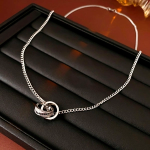 Vue rapprochée du pendentif double anneau en argent avec zircons noirs sur la chaîne
