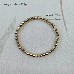 Detailed close-up of 5mm golden stainless steel beaded bracelet with polished finish