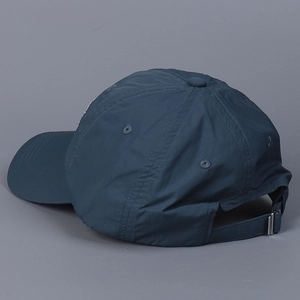Detail of adjustable metal buckle and breathable nylon fabric on navy baseball cap