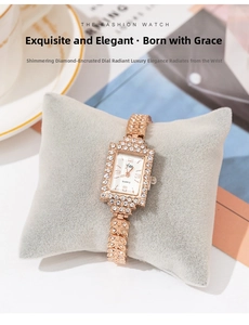 Detail of square rose gold watch with rhinestone leaf chain on a grey velvet pillow