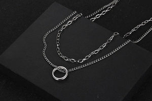 Detail of silver double layer necklace with circle pendant and paperclip chain links