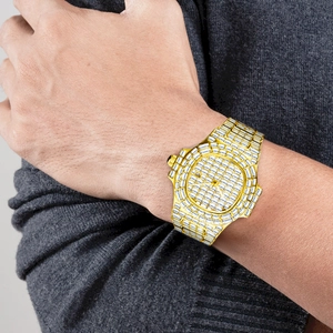 Close-up of luxury gold iced-out quartz watch with square diamonds on male wrist