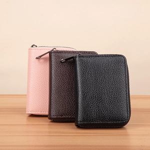 Litchi pattern leather zip card holders in pink, brown and black on wood table